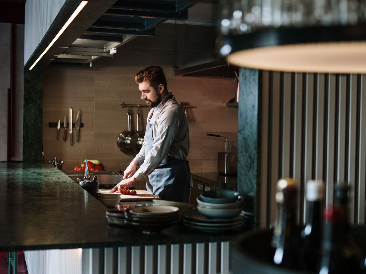 Chef plating a dish with precision on a kitchen counter