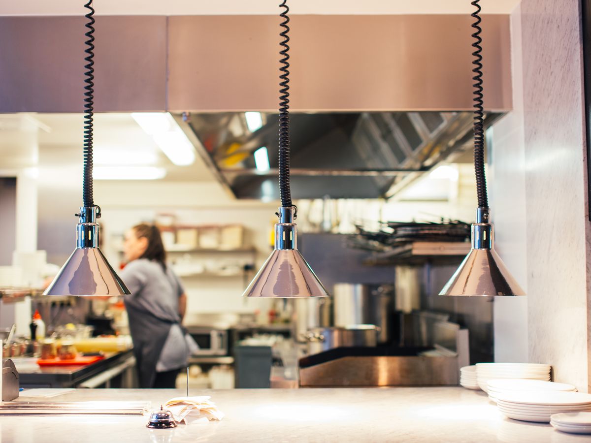 Two chefs working together at the pass in a professional restaurant kitchen