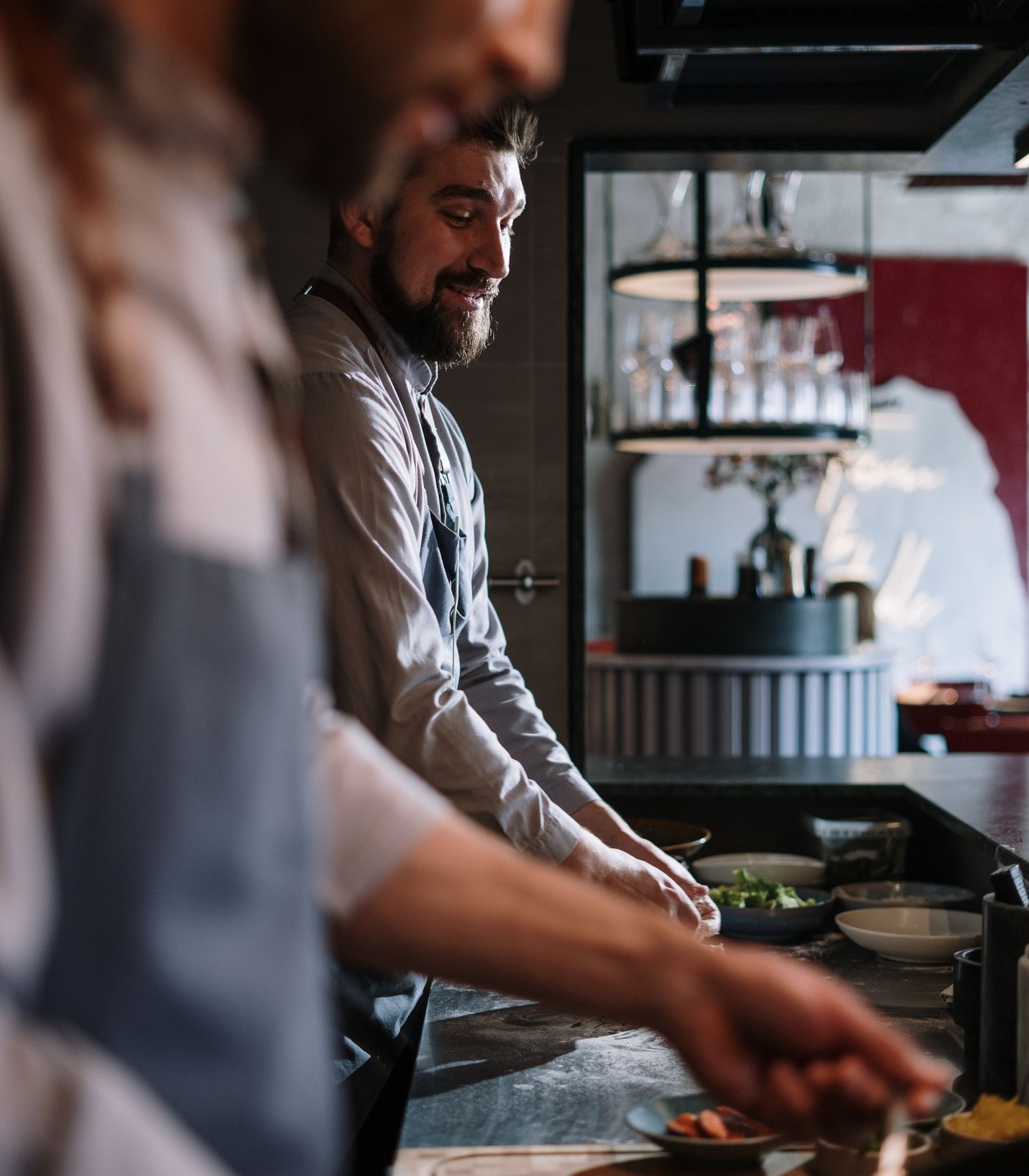 Two chefs working together at the pass in a professional restaurant kitchen
